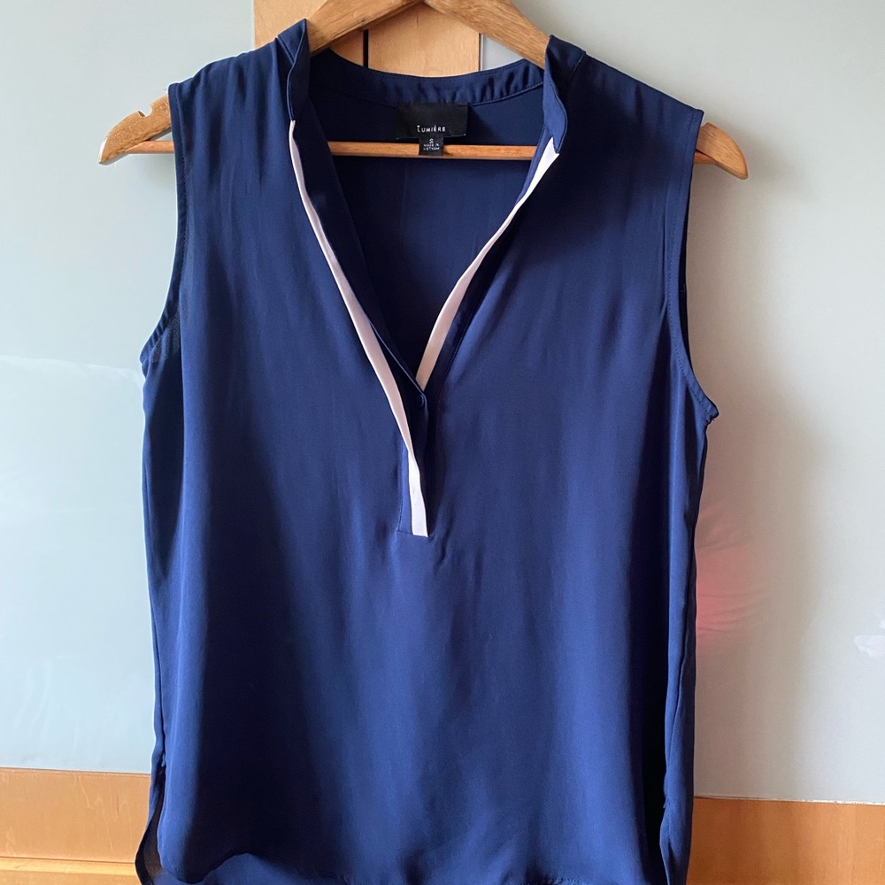 Beautiful navy blue sleeveless blouse with crisp white neckline detail.